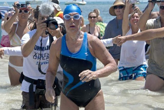 Diana Nyad emerges from the Atlantic Ocean after completing the 111-mile swim