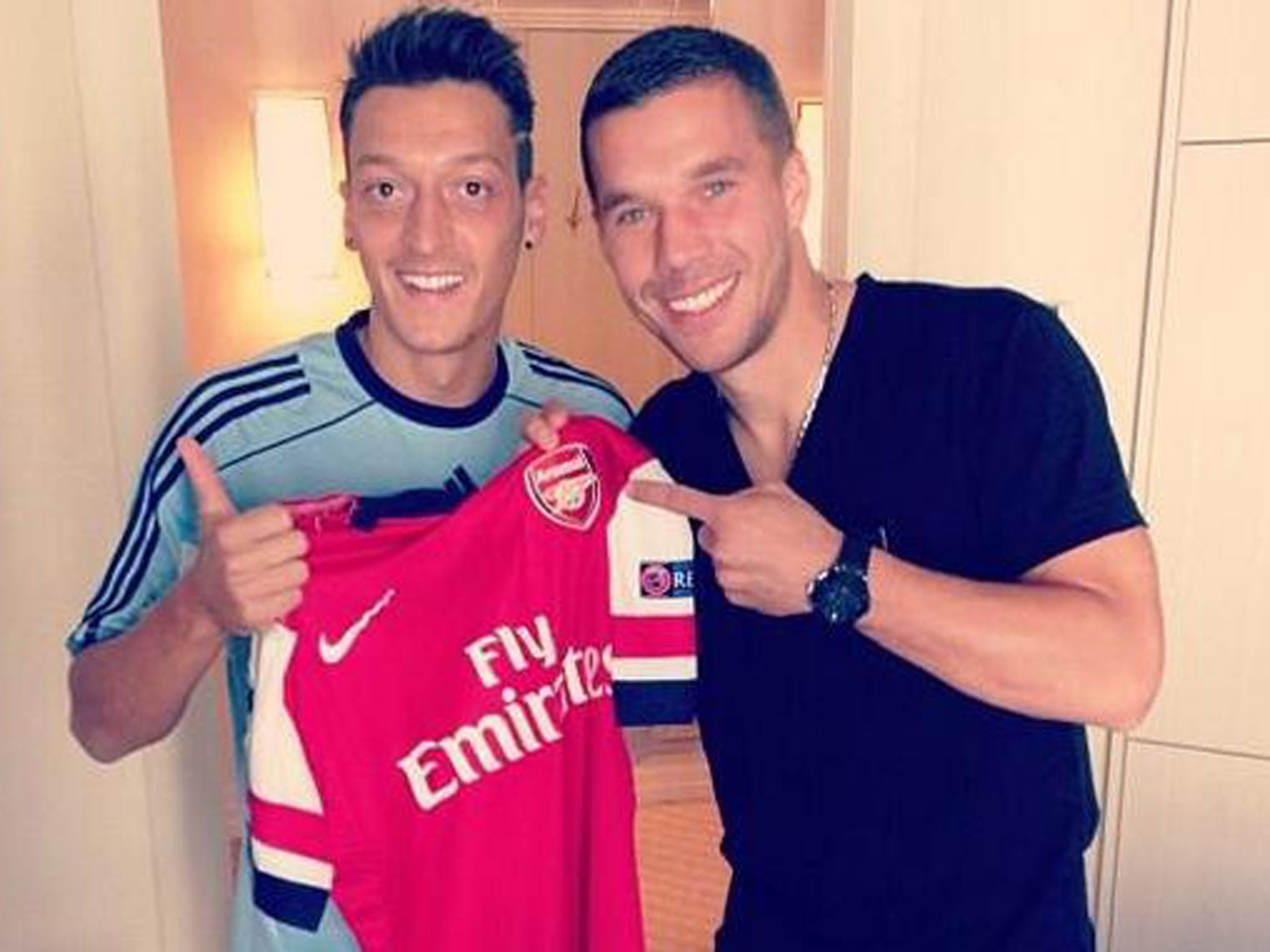 Mesut Ozil poses with new Arsenal team-mate Lukas Podolski while on duty with the Germany. Podolski, currently out with a hamstring injury, was being examined by the national team doctor