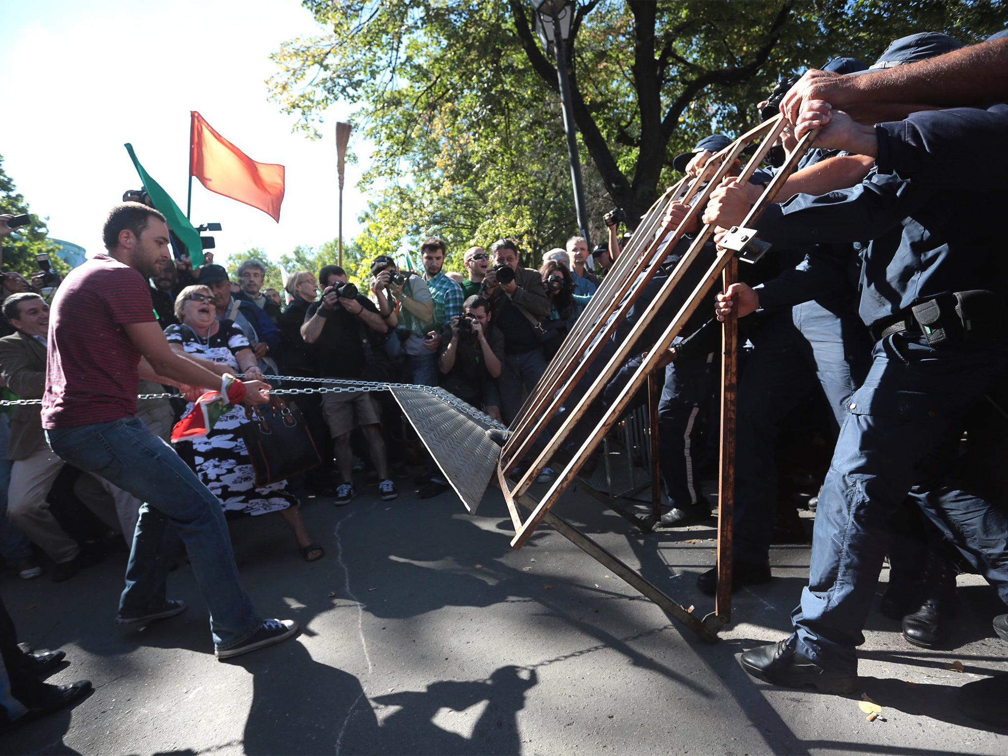 Protesters and police struggle over a fence near parliament