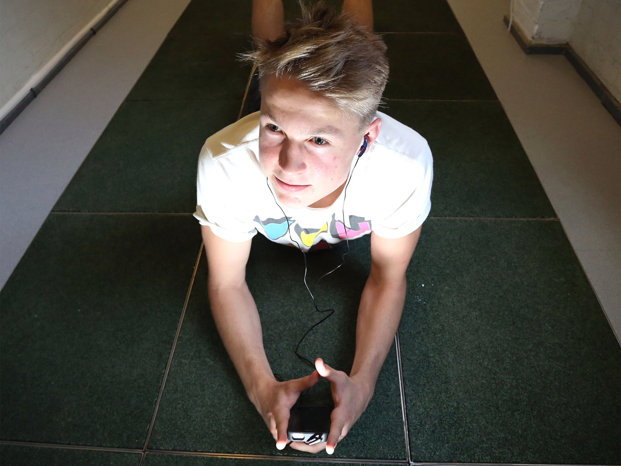 Zach Cole, 17, listens to his iPod which has been charged using energy generated from the kinetic floor tiles