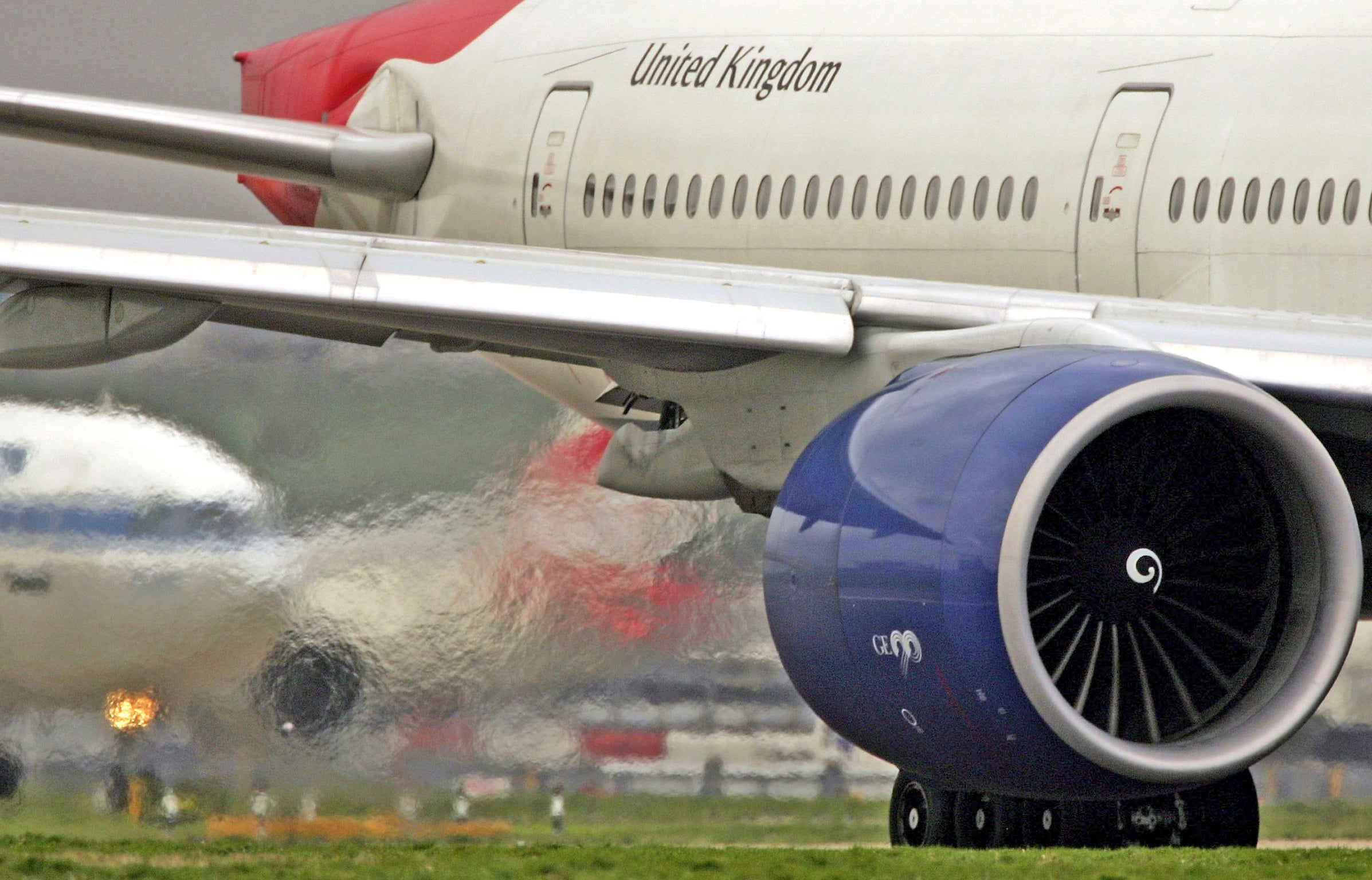 Exhaust emits from the engine of a passenger jet at Heathrow Airport
