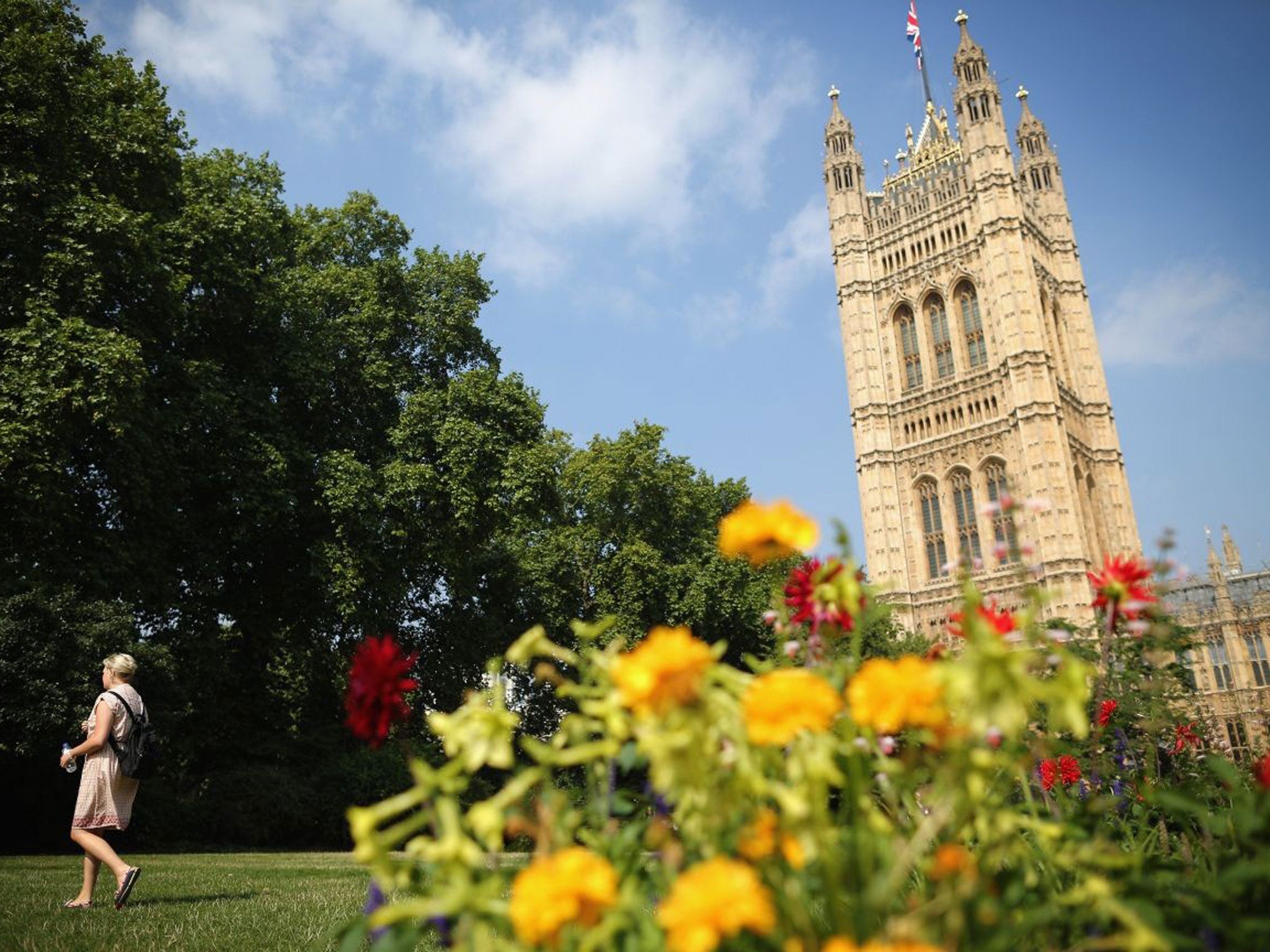 A woman walks through Victoria Tower Gardens on 4 September, 2013, as much of Britain is experiencing higher than average temperatures