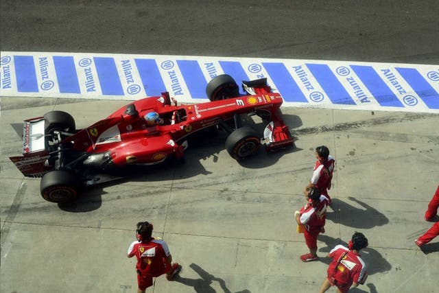 Stand-off: Fernando Alonso drives into the pits during his ill-fated qualifying session yesterday