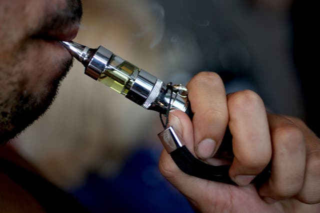 A man tries a flavoured E liquid as he shops for a flavour for his e-cigarette