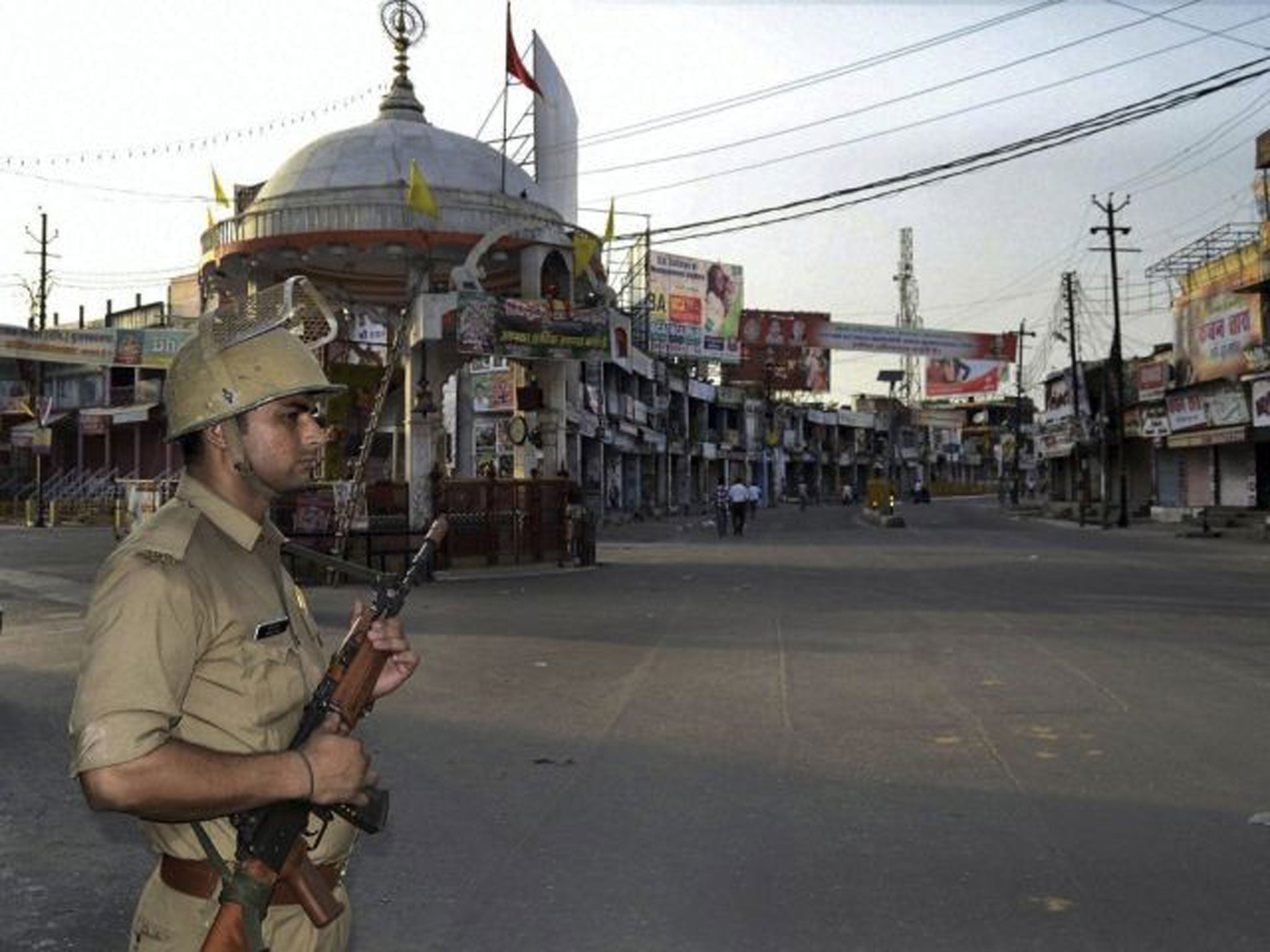 An Indian policeman stands guard during a curfew hours following riots and clashes between two communities in Muzaffarnagar