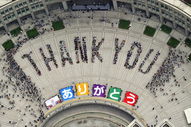Japanese people form the words ‘Thank You’ in a Tokyo square as part of celebrations