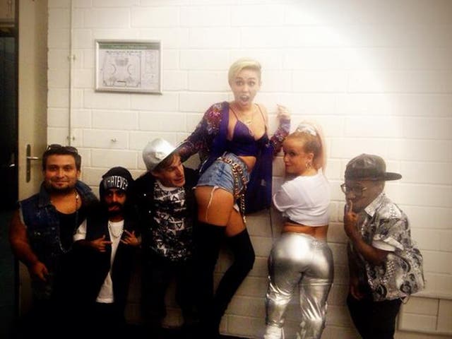 Miley Cyrus poses with dwarves backstage after her performance on German TV show Schlag Den Rabb