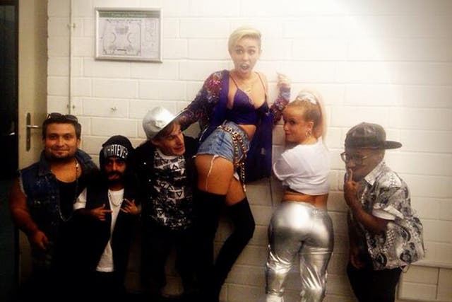 Miley Cyrus poses with dwarves backstage after her performance on German TV show Schlag Den Rabb