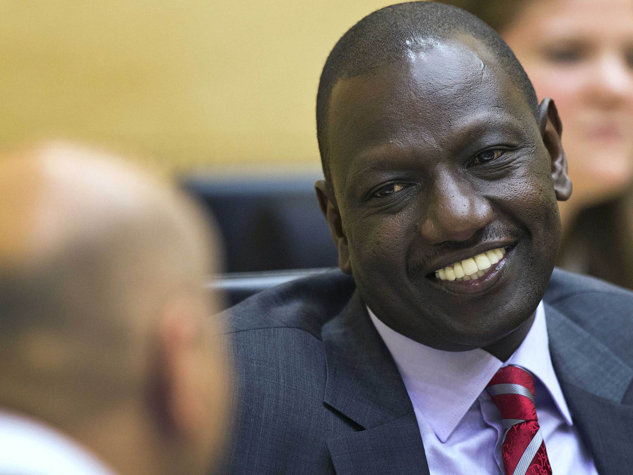 Kenya's Deputy President William Ruto speaks with his defence counsel