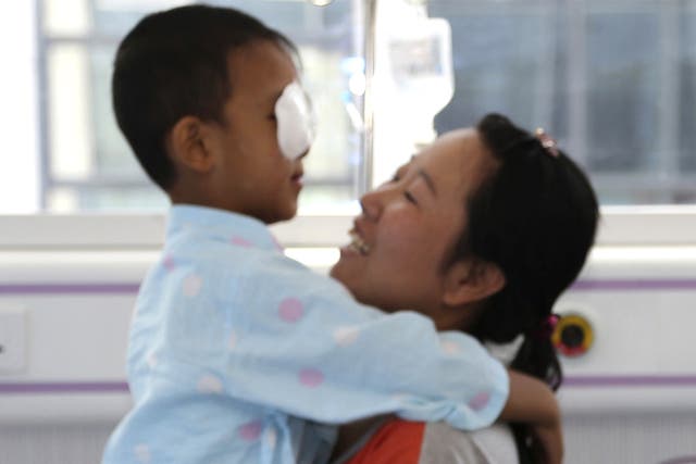 Guo Bin is hugged by his mother before undergoing orbital implants surgery