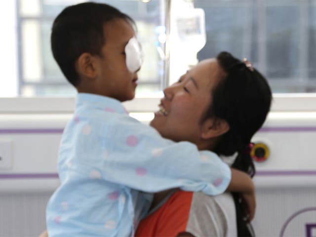 Guo Bin is hugged by his mother before undergoing orbital implants surgery