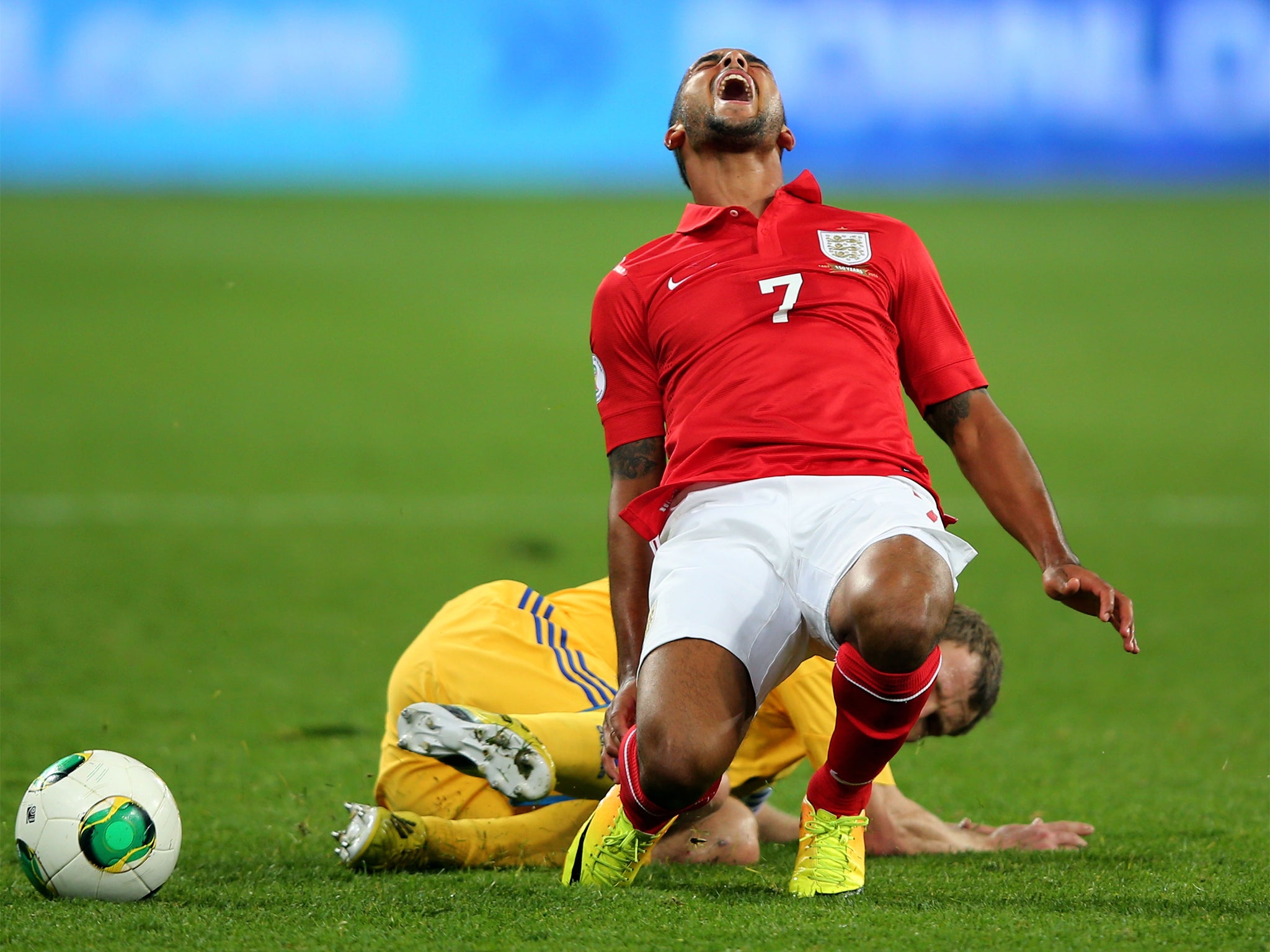 England’s Theo Walcott goes down under a tackle in Kiev