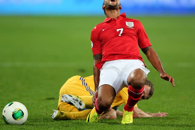 England’s Theo Walcott goes down under a tackle in Kiev