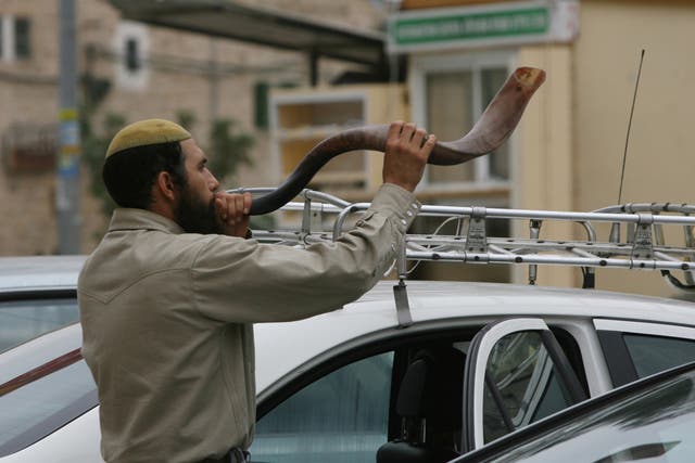 A Jewish settler blows the 'Shofar' horn on the eve of the Day of Atonement, or Yom Kippur