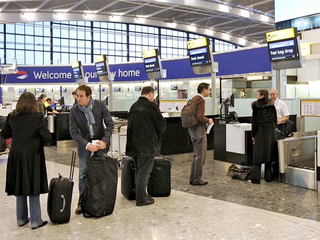 Passengers stand in line to check in baggage at Heathrow