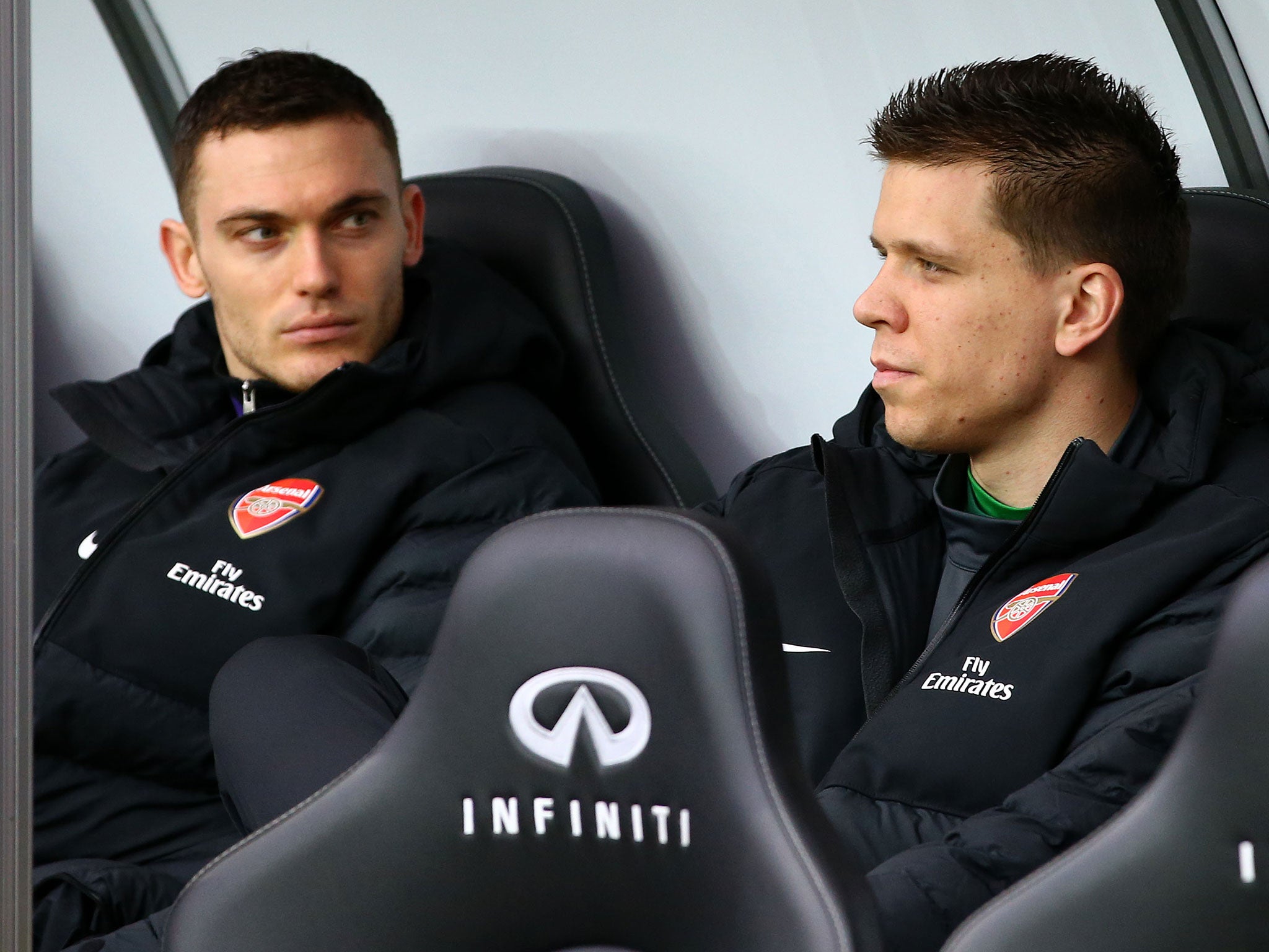 Thomas Vermalen (left) looks on from the bench alongside Wojciech Szczesny