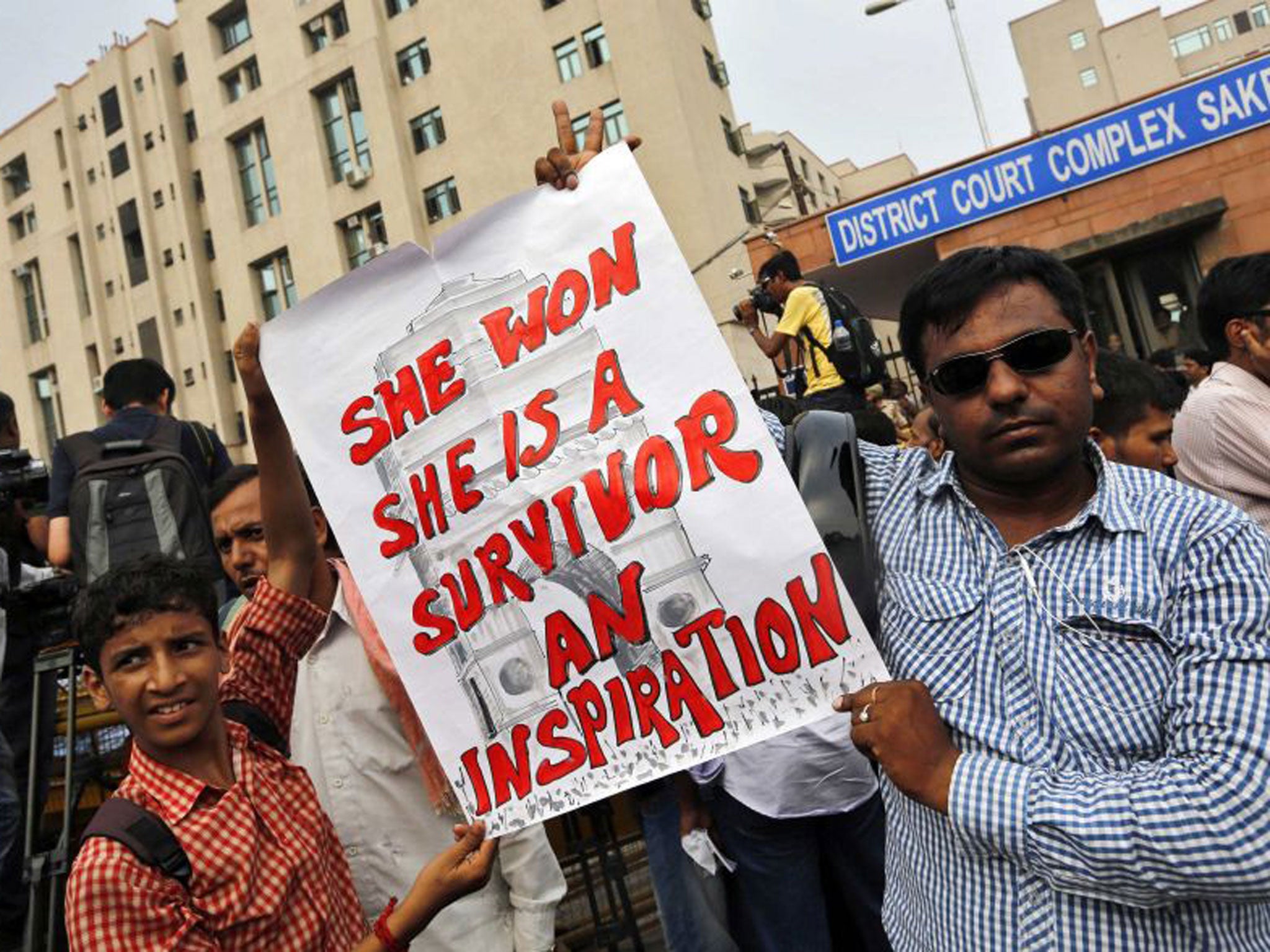 Demonstrators hold placards outside the New Delhi court