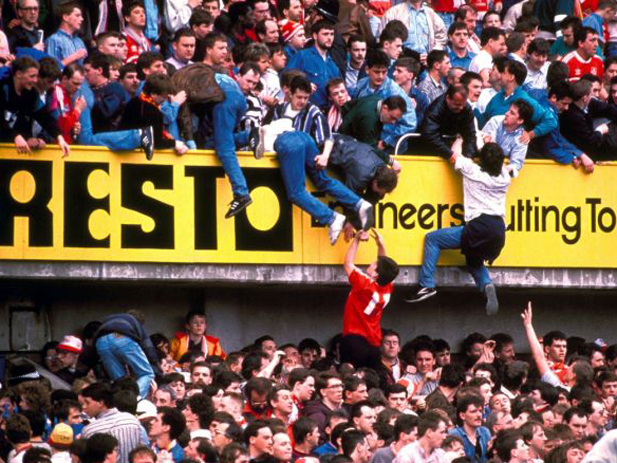 Football fans escape from being crushed in the stands at Hillsborough Stadium