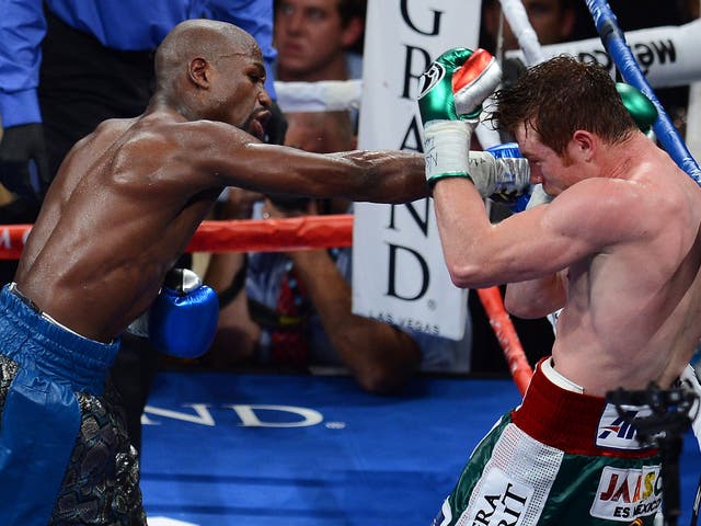 <p>Floyd Mayweather Jr. throws a right at Canelo Alvarez</p>