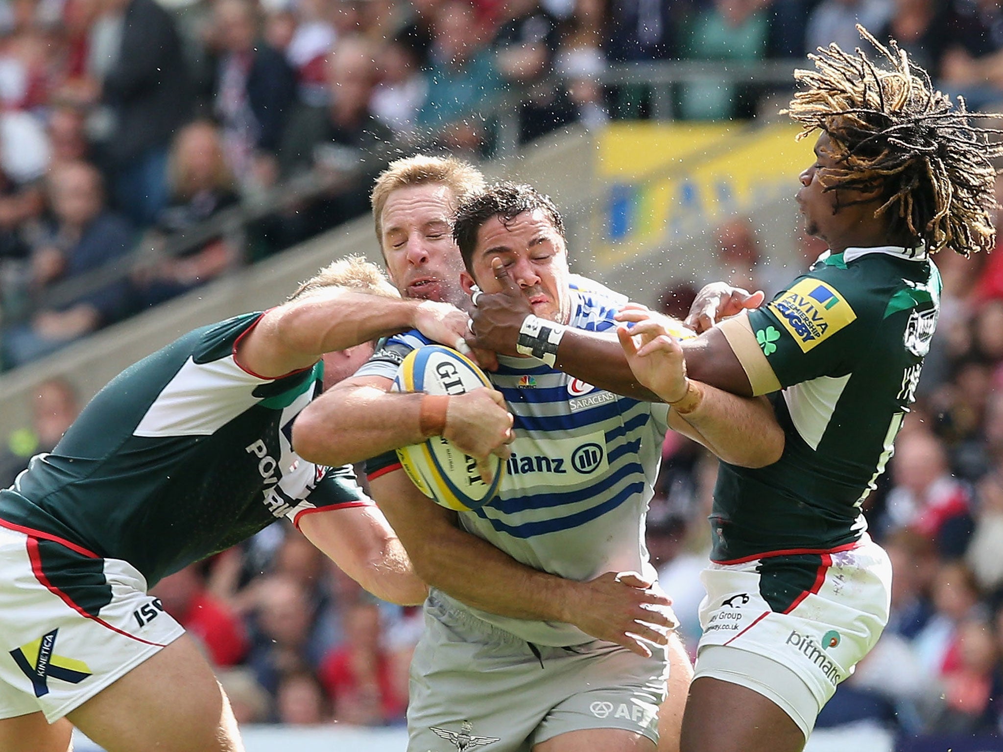 Brad Barritt of Saracens is tackled by Marland Yarde (R) and David Paice