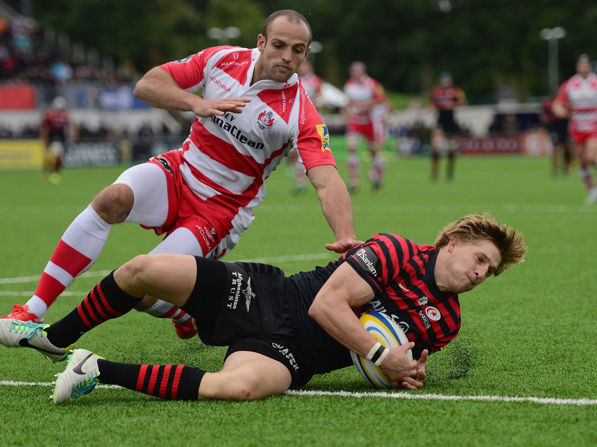 David Streetle of Saracens beats the tackle of Charlie Sharples of Gloucester to score a try