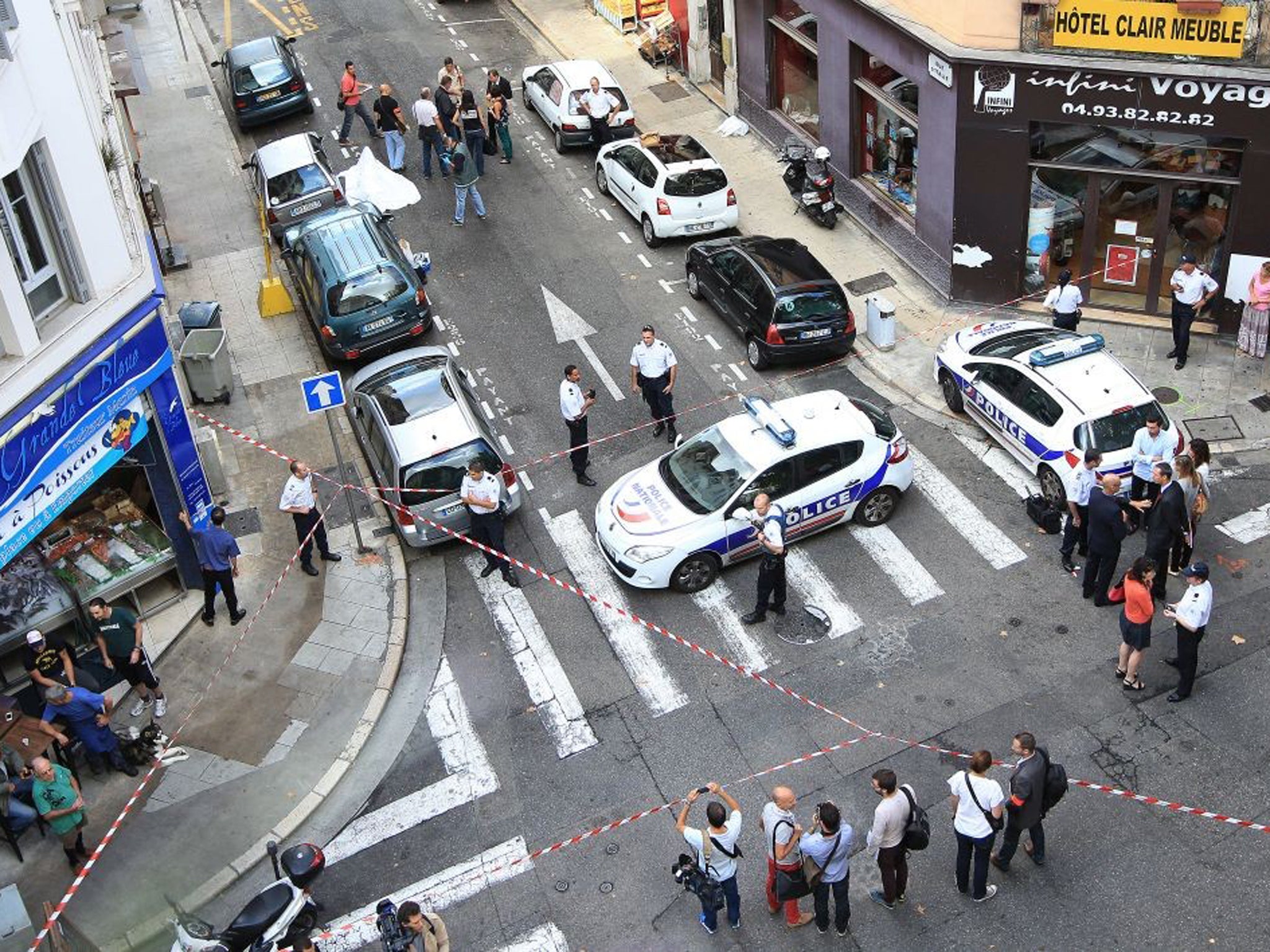 Forensic experts and policemen work on a crime scene near the body of a robber, who was shot dead by a jeweller in Nice
