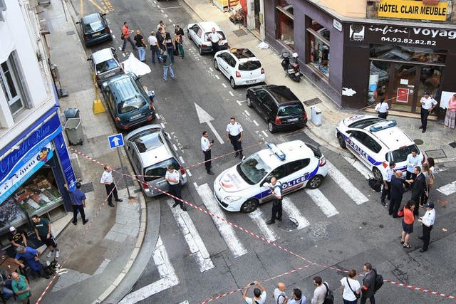 Forensic experts and policemen work on a crime scene near the body of a robber, who was shot dead by a jeweller in Nice