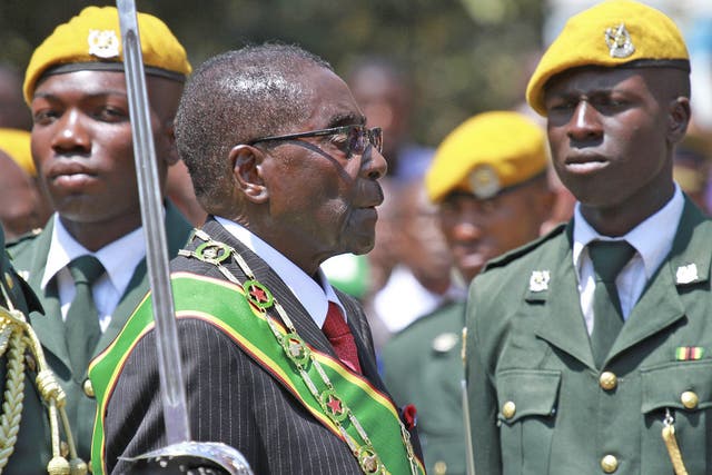 Zimbabwean President Robert Mugabe inspects the guard of honour during the parliamentary ceremony