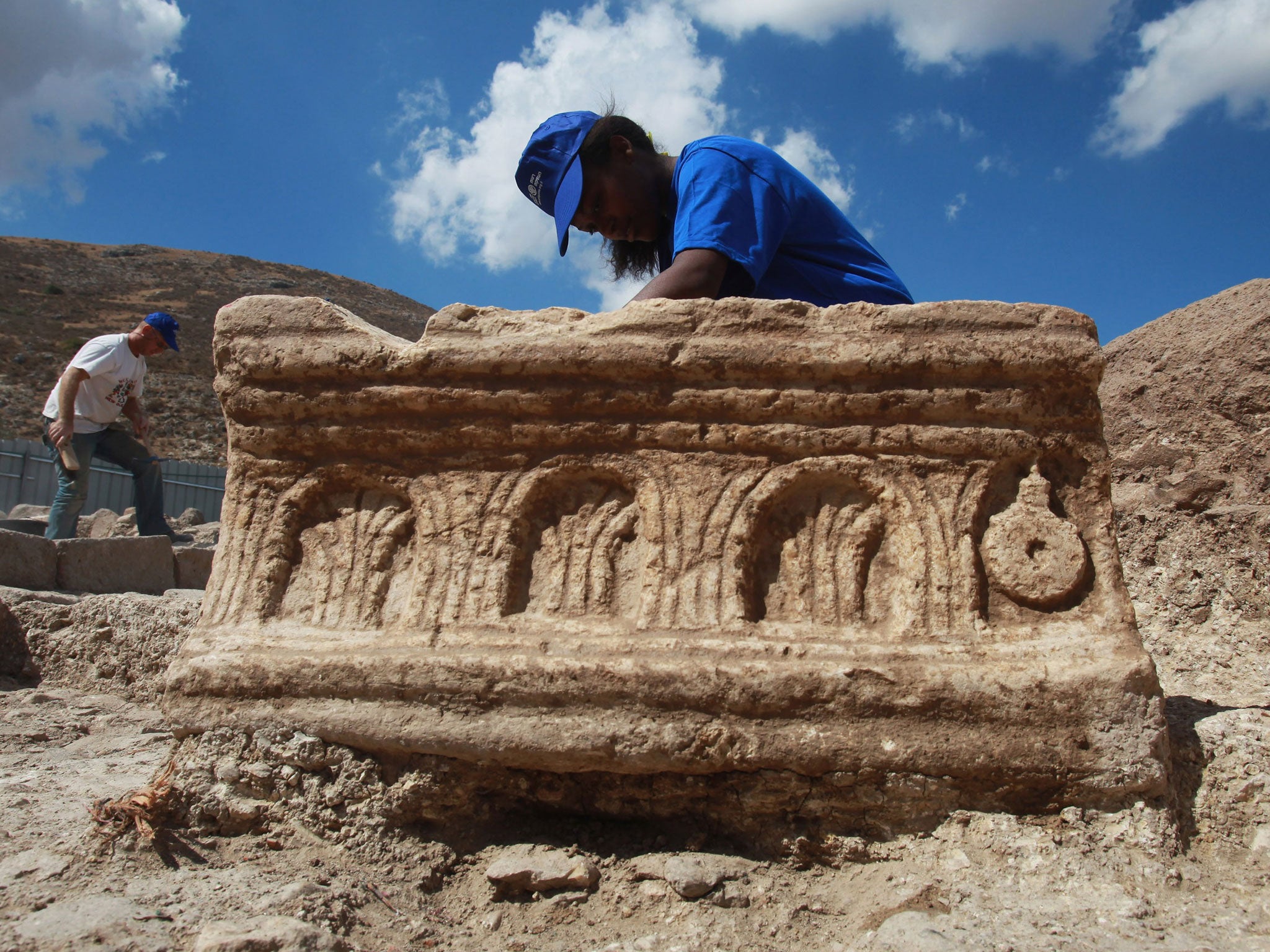 An Israeli Antiquities Authority worker cleans a large carved stone found during excavations of a recently uncovered synagogue on September 13, 2009 at Migdal on the north-western end of the Sea of Galilee in northern Israel.