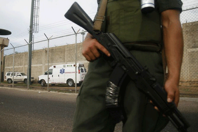 An armed guard outside the prison in Sabaneta in Zulia state, Venezuela, where 16 inmates died during a gang battle