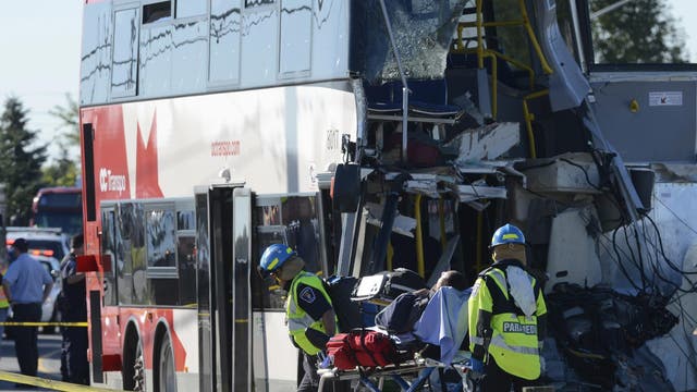 A passenger is taken to an ambulance following a Via Rail train and city bus collision in Ottawa's west end