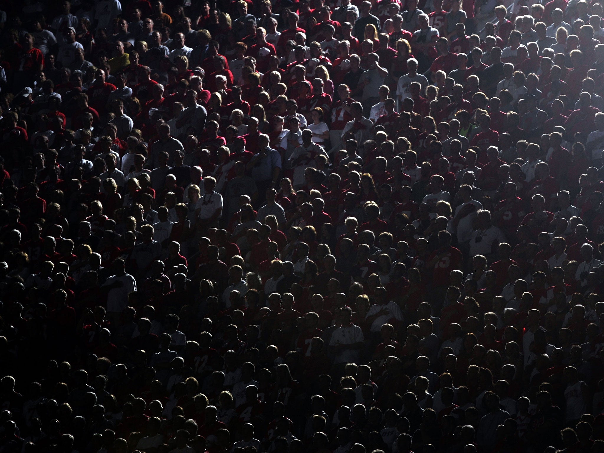 There are just too many of us: A crowd of sports fans seen under the stadium lights