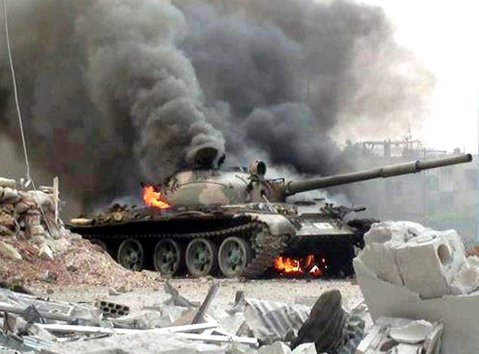 A Syrian military tank on fire during clashes with Free Syrian army fighters in Joubar, a suburb of Damascus