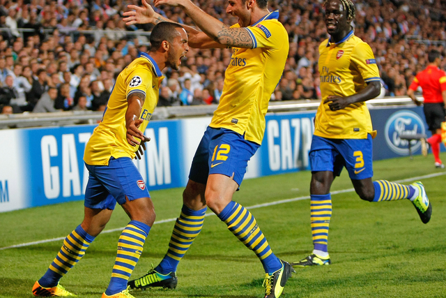 Theo Walcott is joined by his teammates to celebrate the opening goal