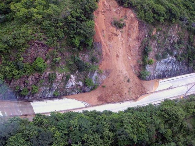 This handout photo taken and released on 18 September, 2013 by Mexico's Interior Ministry press office shows an aerial view of a landslide along a highway going to Acapulco, in the Mexican state of Guerrero, as heavy rains hit the country. 