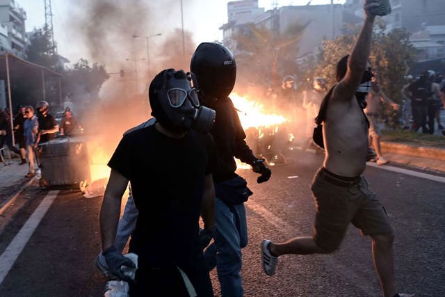Anti-fascist demonstrators clash with riot police in an Athens suburb following the murder of left-wing musician Pavlos Fysass