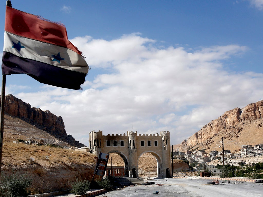 A picture taken on September 18, 2013 shows the Syrian flag flying on the side of a road leading to Syria's ancient Christian town of Maalula, as fighting continues between government forces and rebel fighters. The town lies around 55 kilometres (34 miles