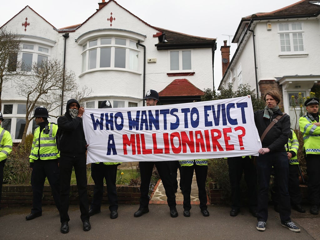 People hold a sign as UK UNCUT supporters protest over the government's changes to the welfare system and the proposed 'Bedroom Tax,' on April 13, 2013 in London, England. The anti-austerity campaigners gathered outside the North London home of Lord Freud