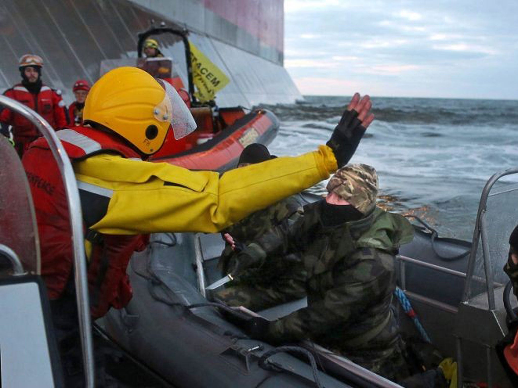 A member of the Russian Coast Guard appears to threaten a Greenpeace activist with a knife