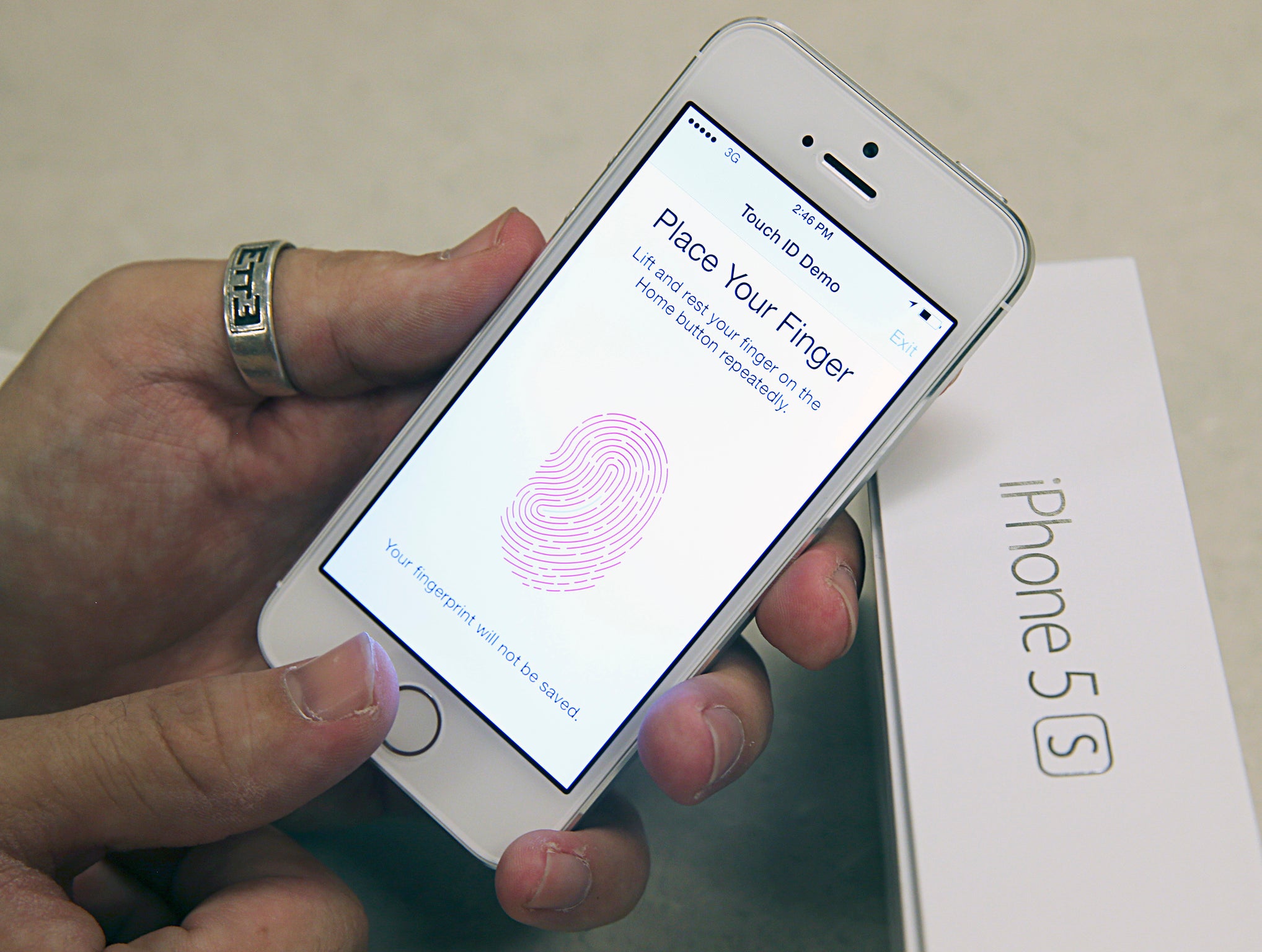 An employee tests the fingerprint scanner on the new Apple iPhone 5S at a Verizon store in Orem, Utah September 19, 2013.