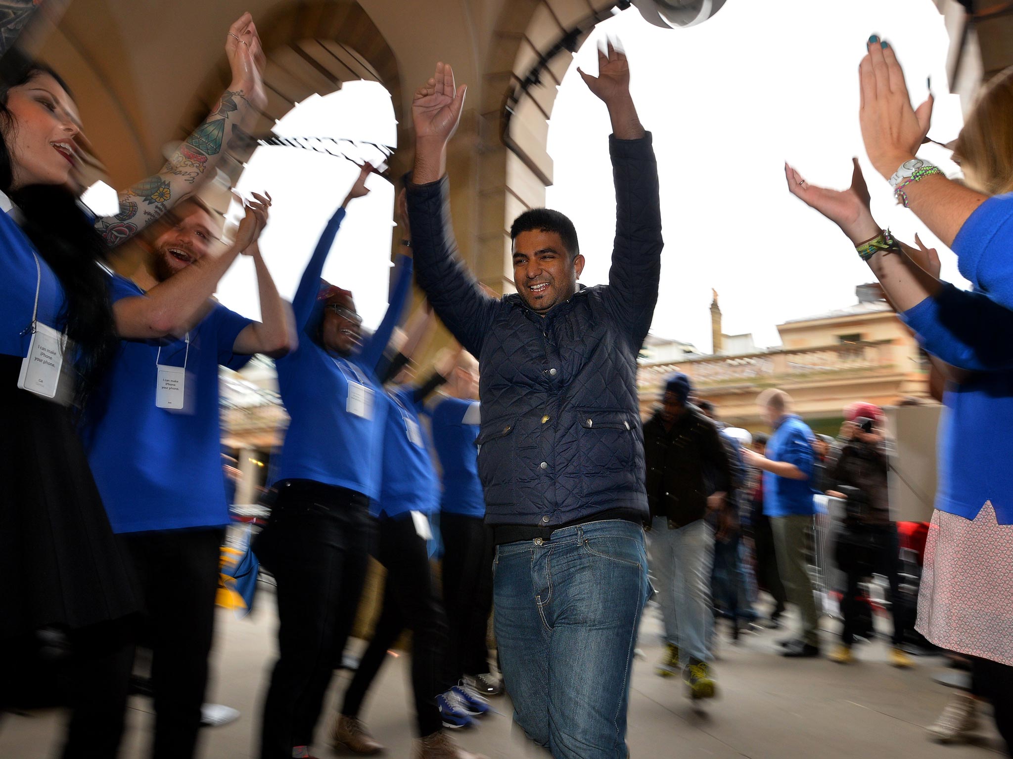 Customers are cheered on by Apple staff as they enter the Apple store ahead of the iPhone 5S and 5C going on sale in central London