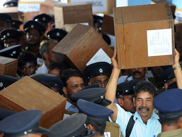 Sri Lankan election workers carry ballot boxes before boarding buses as they prepare to go to their polling centres in Jaffna