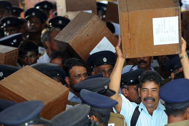 Sri Lankan election workers carry ballot boxes before boarding buses as they prepare to go to their polling centres in Jaffna