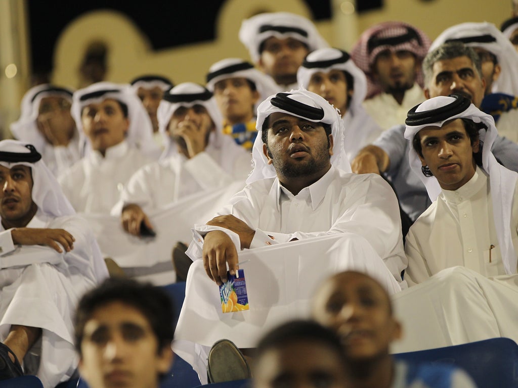 Fans wearing traditional local dress attend the Gharafa vs. Kharaitiyat Qatar Stars League football match at Al Gharafa Stadium on October 23, 2011 in Doha, Qatar. Qatar will host the 2022 FIFA World Cup football competition and is slated to tackle a vari