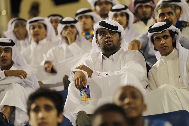 Fans wearing traditional local dress attend the Gharafa vs. Kharaitiyat Qatar Stars League football match at Al Gharafa Stadium on October 23, 2011 in Doha, Qatar. Qatar will host the 2022 FIFA World Cup football competition and is slated to tackle a vari