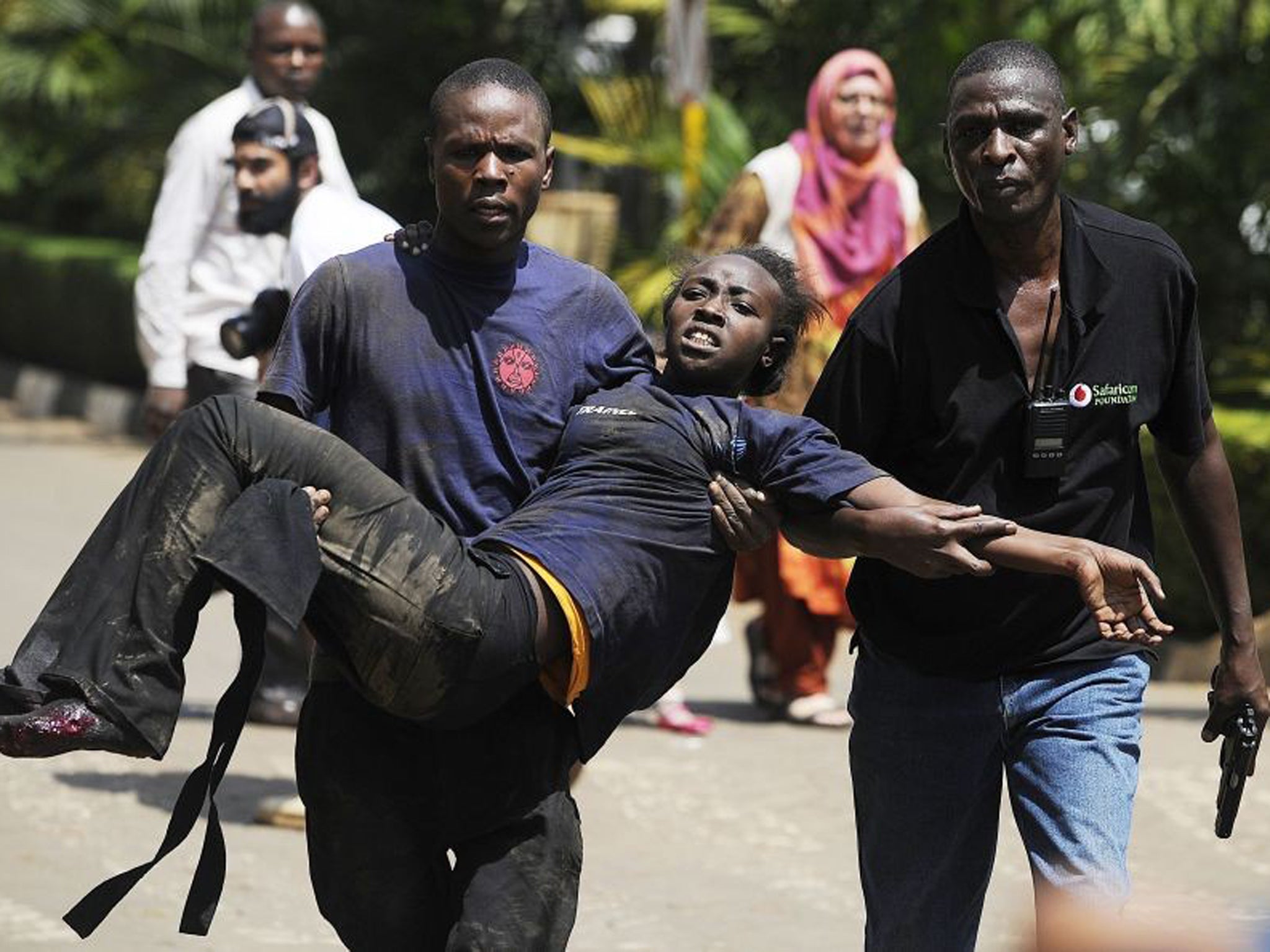 A journalist rescues a woman injured in a shootout between armed men and the police at the Westgate shopping mall in Nairobi