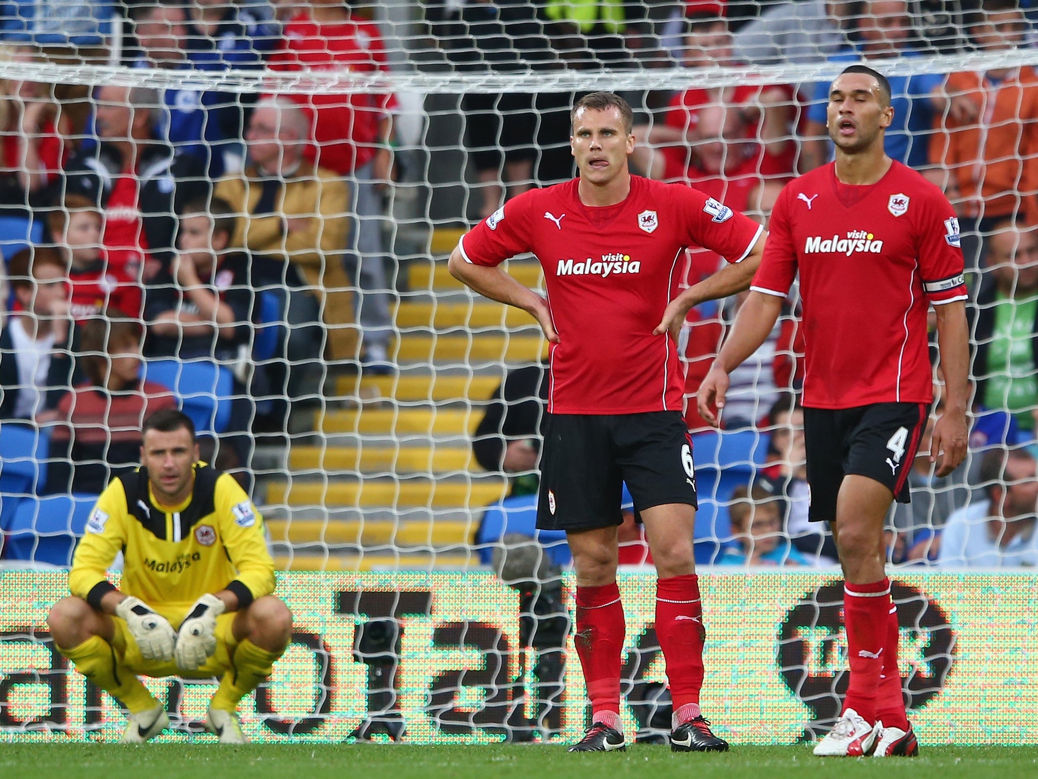 A dejected David Marshall, Ben Turner and Steven Caulker look on after Paulinho's injury-time winner