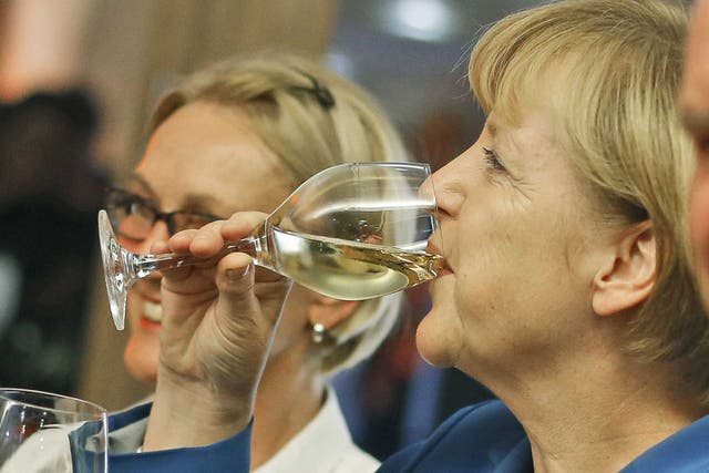 German Chancellor Angela Merkel drinks a glass of wine at the party headquarters after the elections