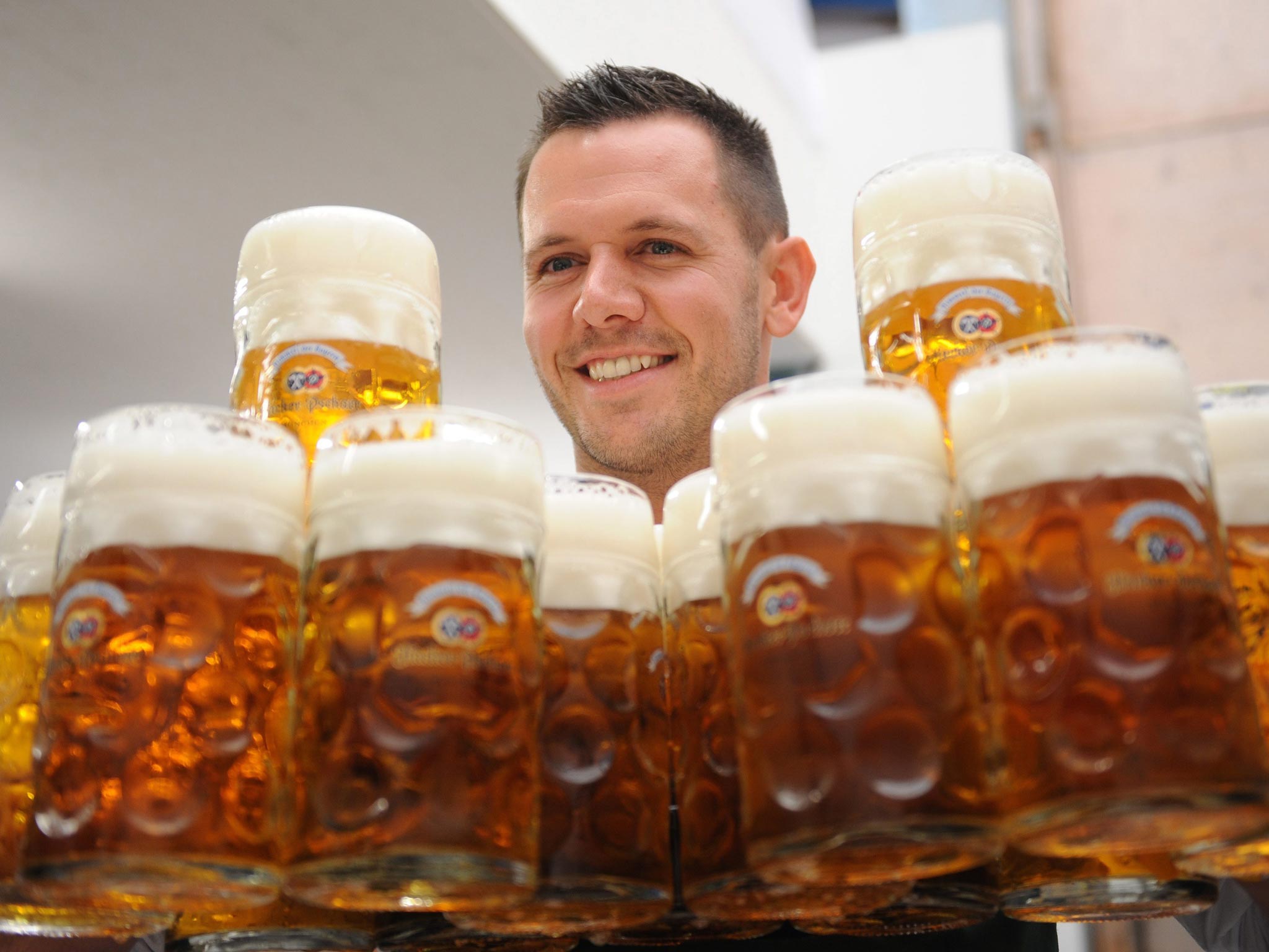 Bartender Peter carries 16 mugs of beer in a beer tent during the Oktoberfest at the Theresienwiese in Munich, Germany