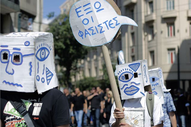 Demonstrators carry a placard which reads " Fascists Out " during a protest in central Athens
